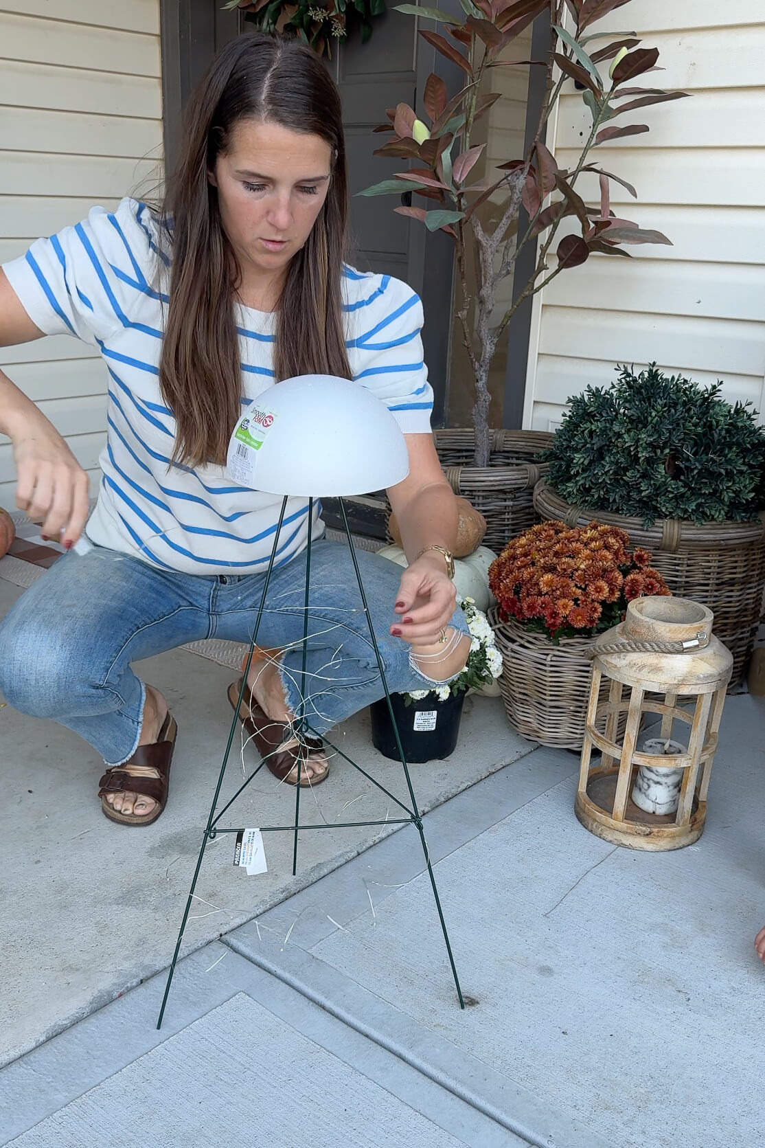 Adding string lights to my DIY ghost porch decor.